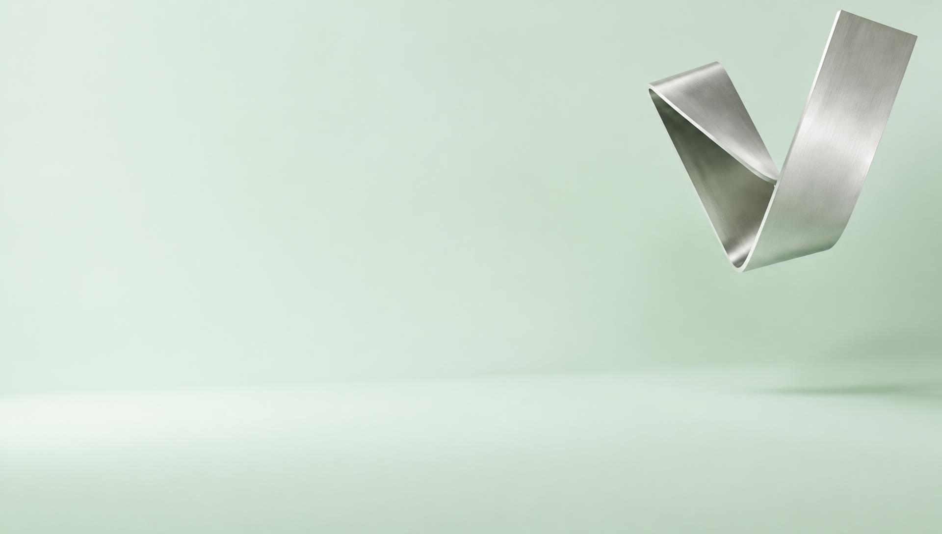 Sculptural brushed-metal V in a light mint studio
